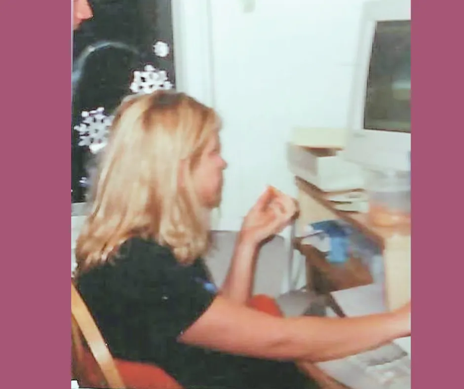 Randi working at a desktop computer in a dining room in 2001
